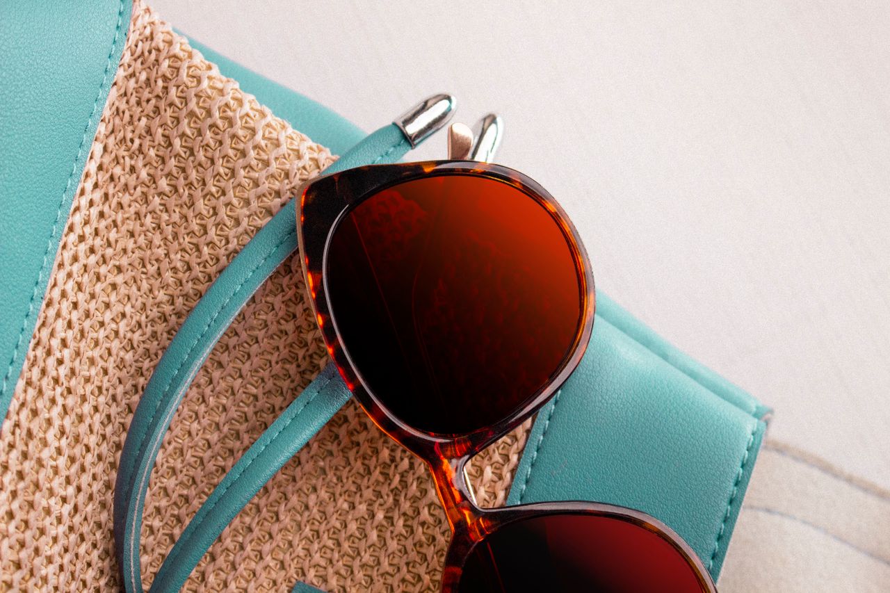 services-06 Fashionable sunglasses on a straw bag, perfect for summer styles.